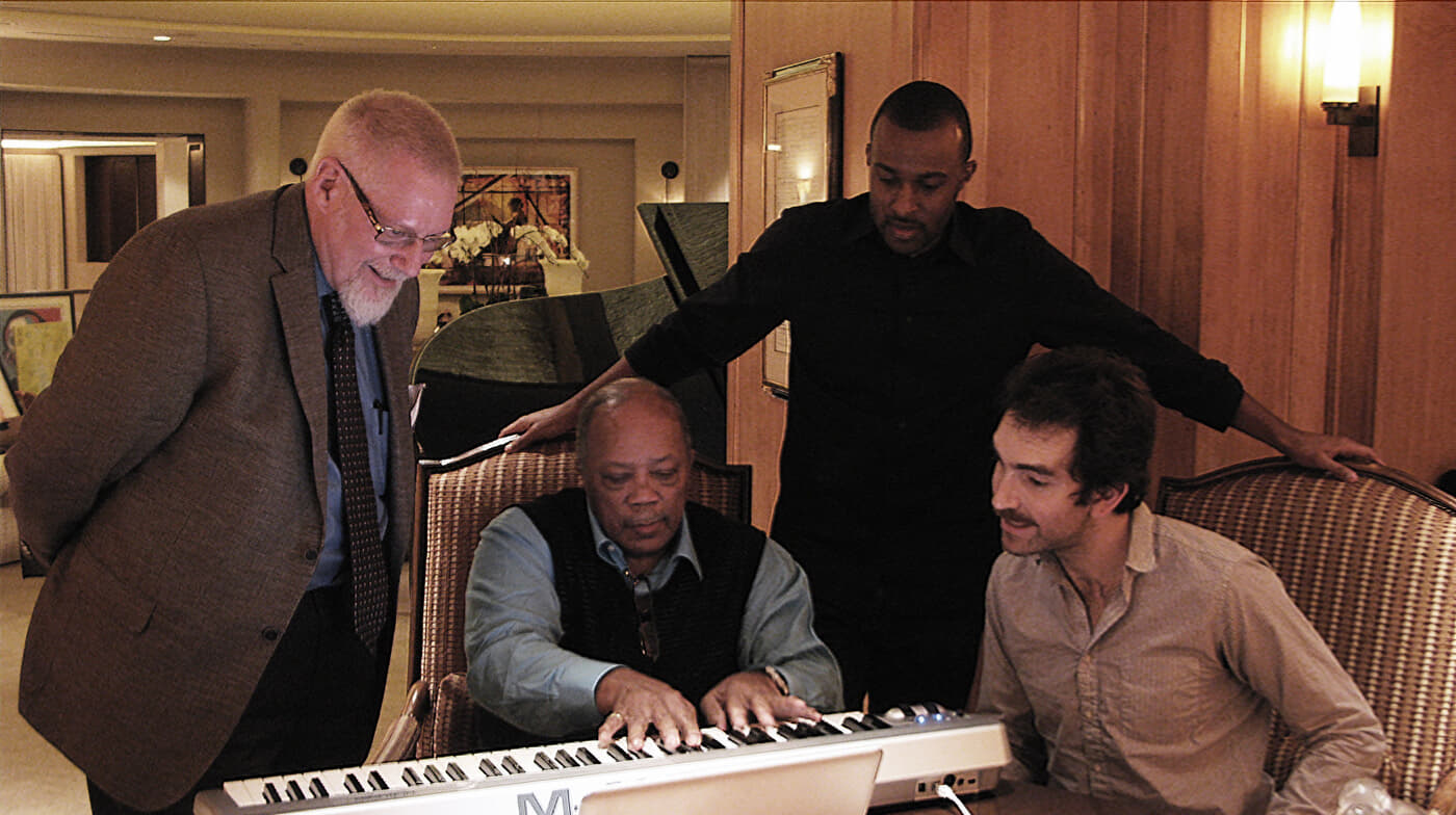 Playground Sessions piano teachers including David Sides watch as Quincy Jones plays a keyboard with the Playground Sessions piano learning app